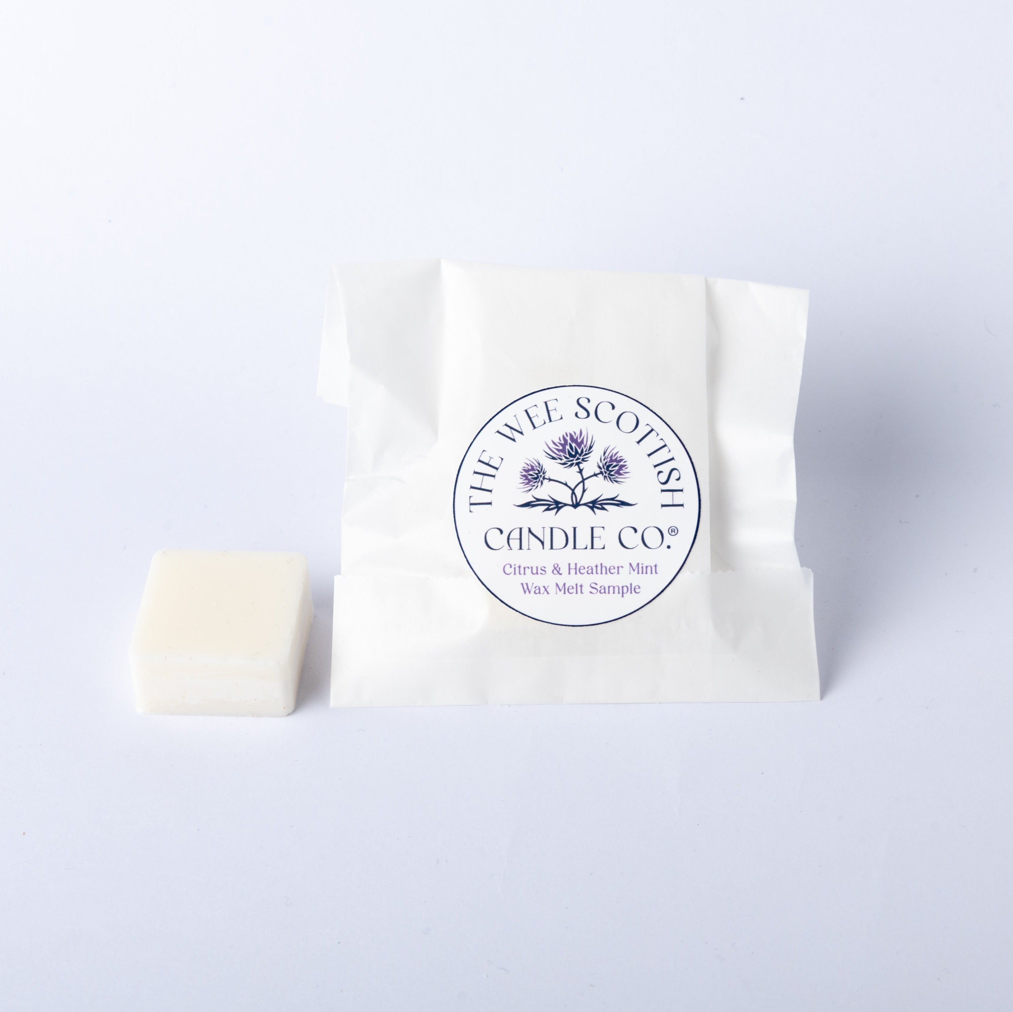 White wax melt with a visible 'The Wee Scottish Candle Company' brand label on a light grey background
