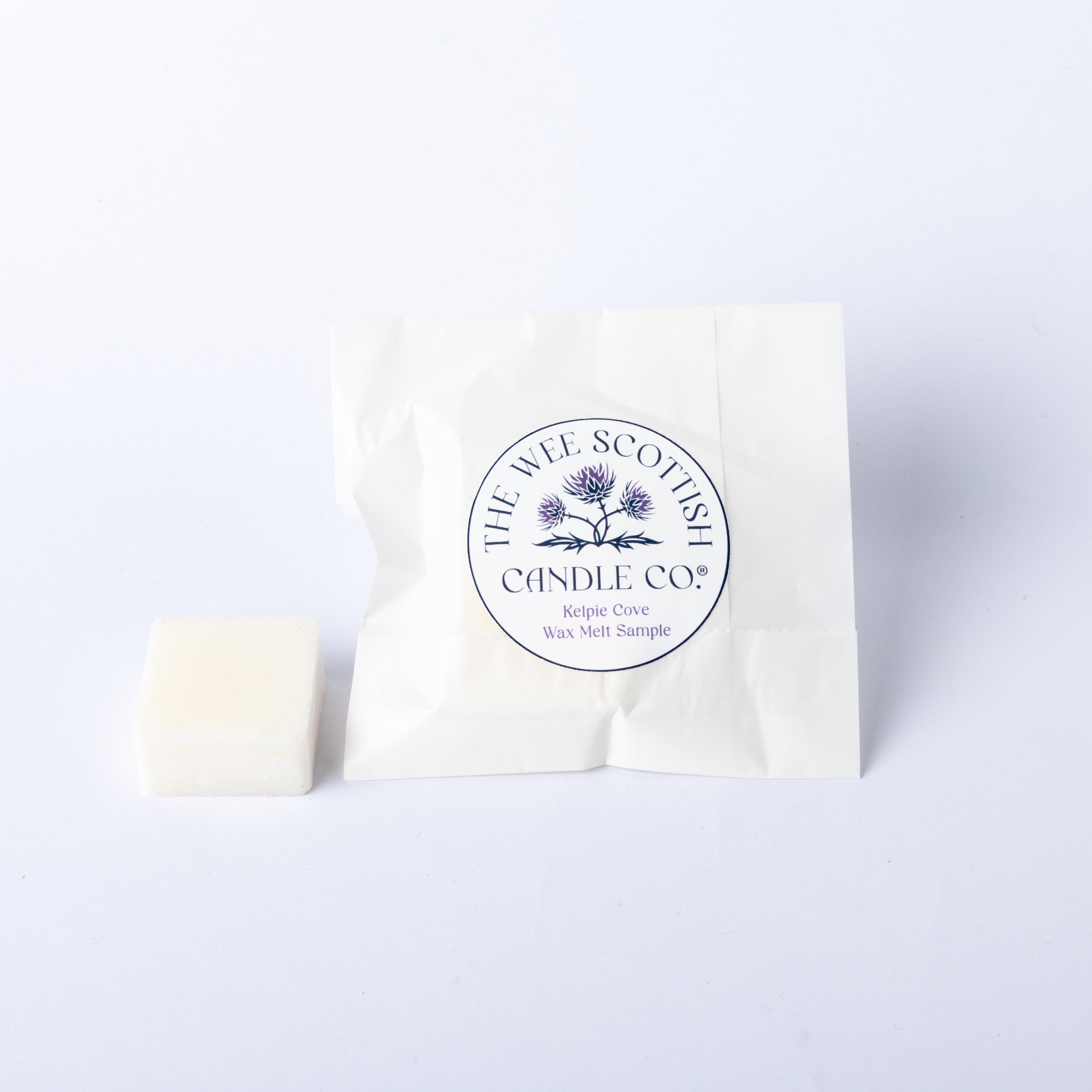White wax melt sample and packaging with 'The Wee Scottish Candle Co.' logo on a white background